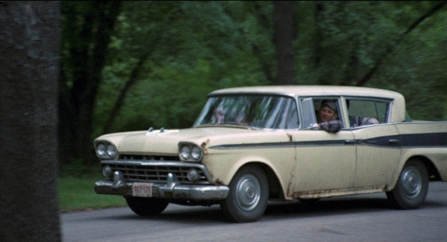 Wide shot frame from Medium Cool — plate, street, car