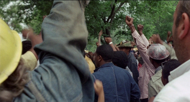 Wide shot frame from Medium Cool — standing, person, human face