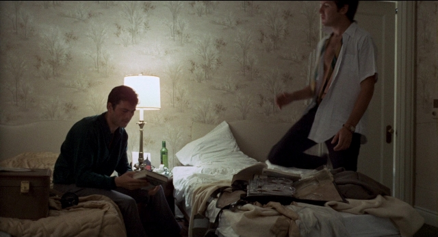 Wide shot frame from Medium Cool — sitting, book, standing
