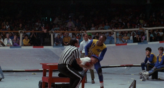 Wide shot frame from Medium Cool — sitting, standing, hat
