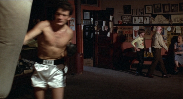 Wide shot frame from Medium Cool — standing, room, door