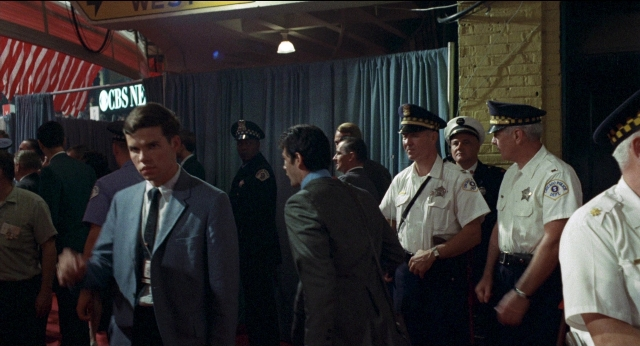 Wide shot frame from Medium Cool — standing, room, uniform