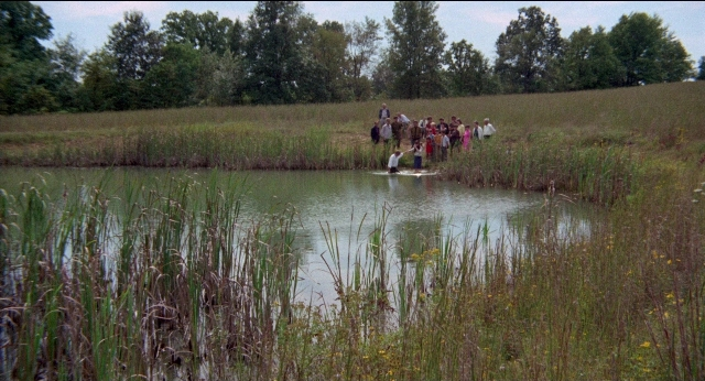 Wide shot frame from Medium Cool — standing, water, person