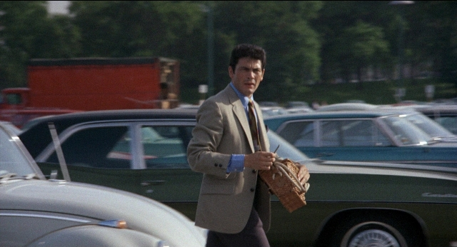 Wide shot frame from Medium Cool — walking, car, hand