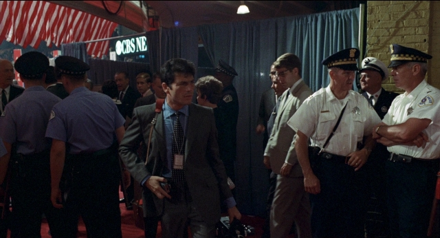 Wide shot frame from Medium Cool — standing, room, dialogue