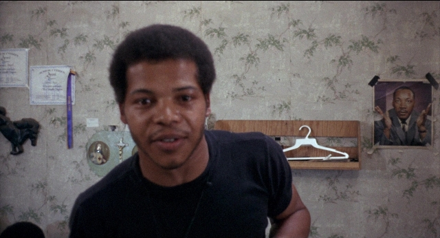 Medium shot frame from Medium Cool — standing, shirt, face