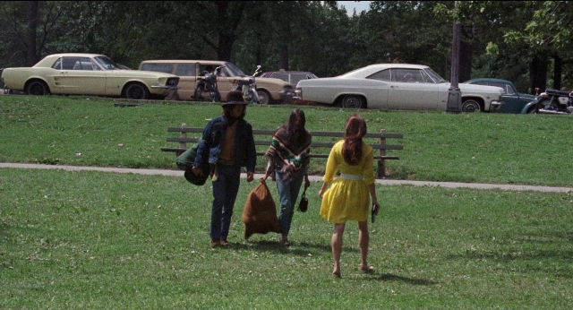 Wide shot frame from Medium Cool — walking, street, hat