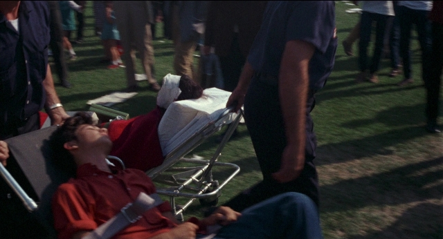 Wide shot frame from Medium Cool — sitting, standing, shirt