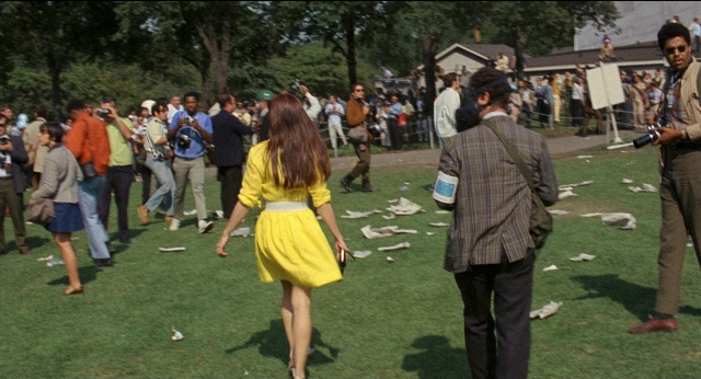 Wide shot frame from Medium Cool — standing, walking, suit