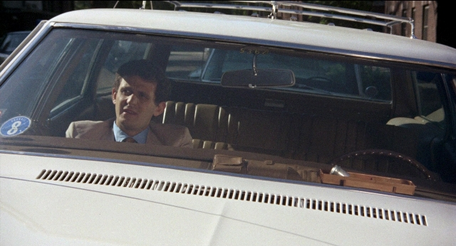 Wide shot frame from Medium Cool — sitting, plate, street
