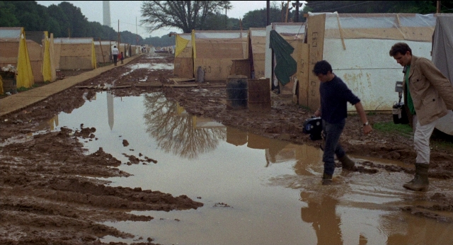 Frame from Medium Cool — walking, water, rain