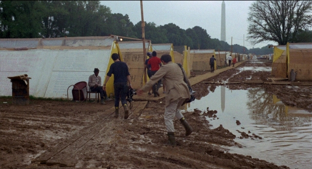 Wide shot frame from Medium Cool — water, person, footwear
