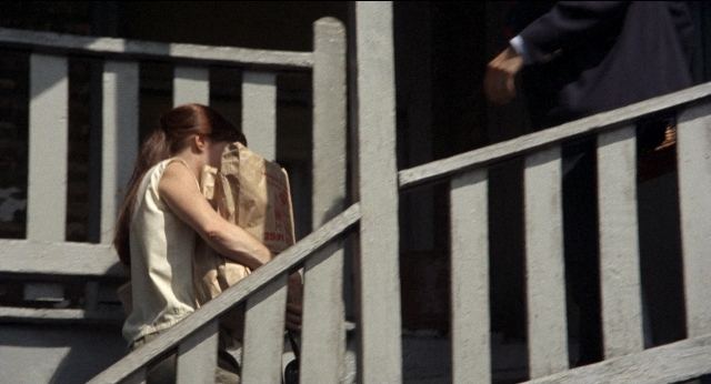 Wide shot frame from Medium Cool — standing, walking, suit