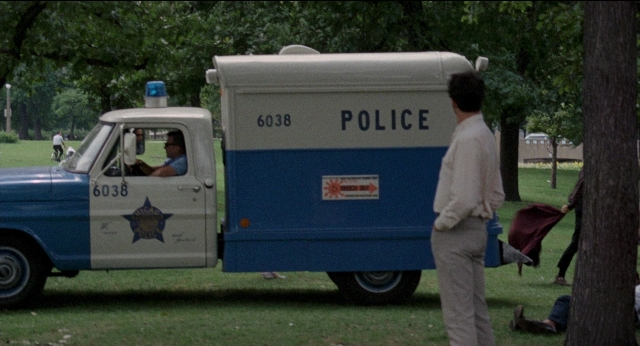 Wide shot frame from Medium Cool — sitting, standing, truck