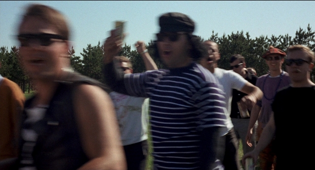 Medium shot frame from Medium Cool — standing, hat, hand