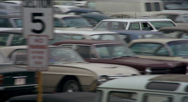 Wide shot frame from Medium Cool — street, car, wheel