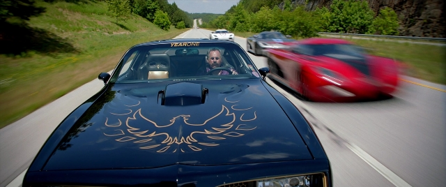 Wide shot frame from Need for Speed — sitting, street, car