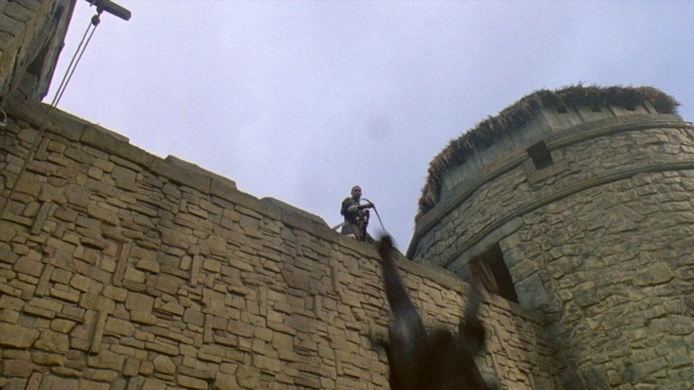 Wide shot frame from Robin Hood: Prince of Thieves — standing, hat, hand