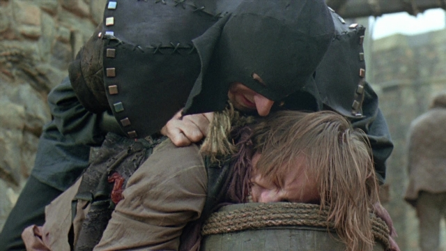 Wide shot frame from Robin Hood: Prince of Thieves — hat, hug, hair