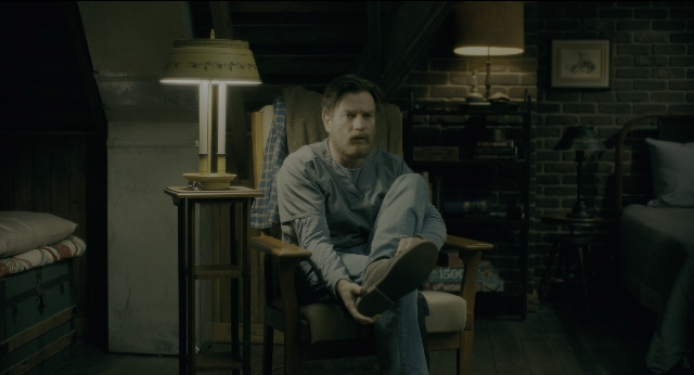 Wide shot frame from Doctor Sleep — sitting, book, room