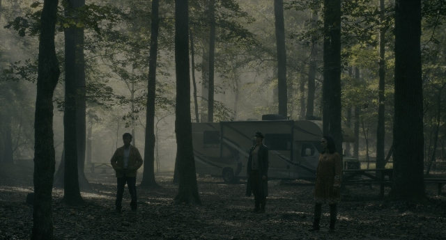 Wide shot frame from Doctor Sleep — standing, table, forest
