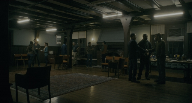 Wide shot frame from Doctor Sleep — standing, room, table