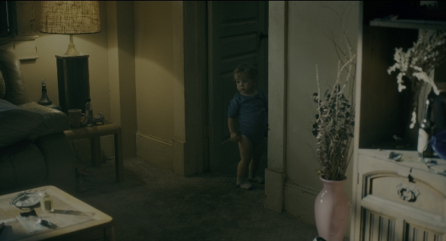 Wide shot frame from Doctor Sleep — standing, room, table