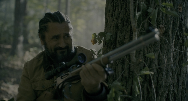 Wide shot frame from Doctor Sleep — standing, gun, beard