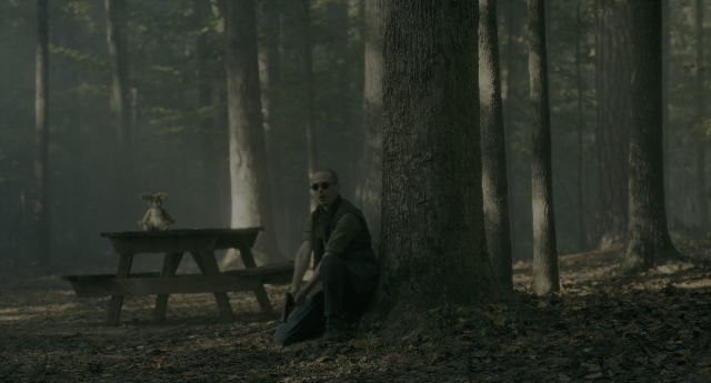 Wide shot frame from Doctor Sleep — sitting, table, hand