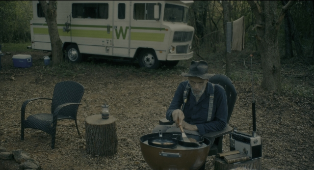 Wide shot frame from Doctor Sleep — sitting, table, hat