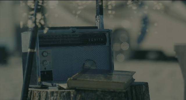 Wide shot frame from Doctor Sleep — sitting, book, home appliance