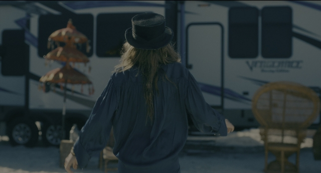 Wide shot frame from Doctor Sleep — standing, table, hat
