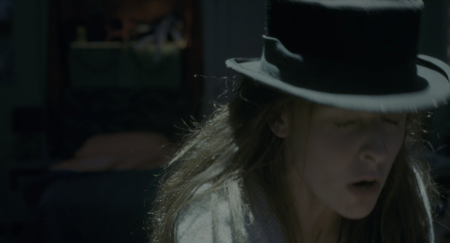 Wide shot frame from Doctor Sleep — table, hat, face