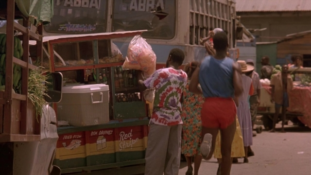 Wide shot frame from Cool Runnings — walking, street, dress