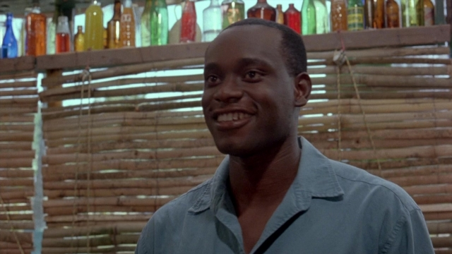 Wide shot frame from Cool Runnings — standing, room, shirt