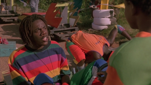Wide shot frame from Cool Runnings — sitting, shirt, person