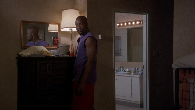 Wide shot frame from Cool Runnings — standing, room, bed