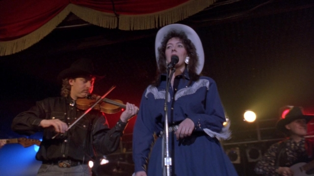 Frame from Cool Runnings — hat, hand, dress