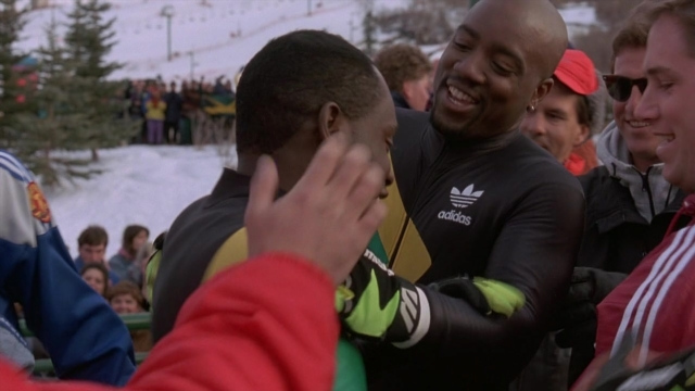 Wide shot frame from Cool Runnings — hug, person, human face