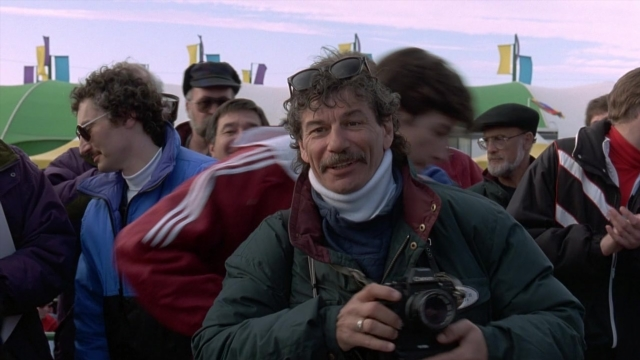 Wide shot frame from Cool Runnings — mustache, camera, hair