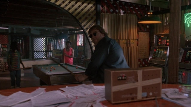 Wide shot frame from Cool Runnings — standing, room, table