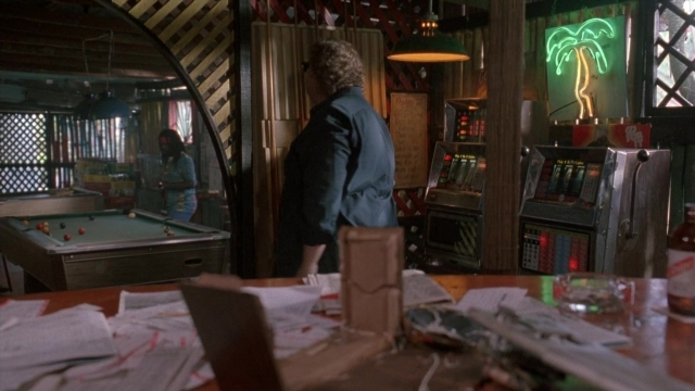 Wide shot frame from Cool Runnings — standing, room, table