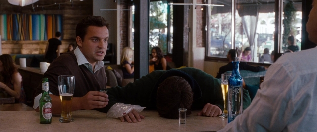 Wide shot frame from No Strings Attached — sitting, shirt, beer