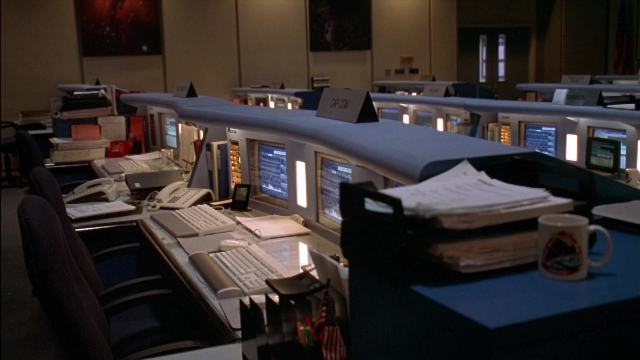 Wide shot frame from Rocketman — desk, room, office