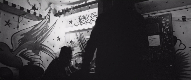 Wide shot frame from The Forty-Year-Old Version — sitting, room, table