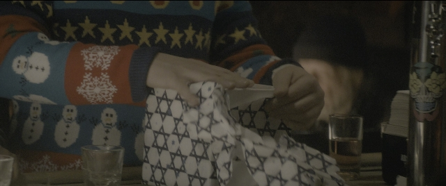 Medium shot frame from The Night Before — sitting, room, table