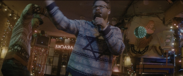 Wide shot frame from The Night Before — standing, room, hat