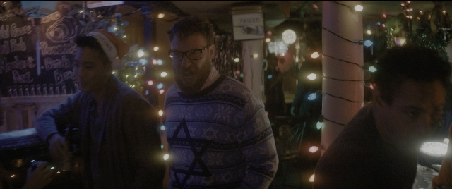 Wide shot frame from The Night Before — standing, room, shirt