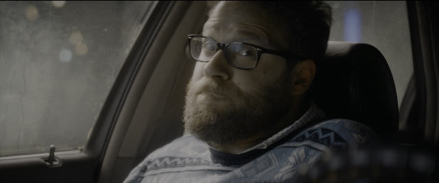 Wide shot frame from The Night Before — sitting, car, beard