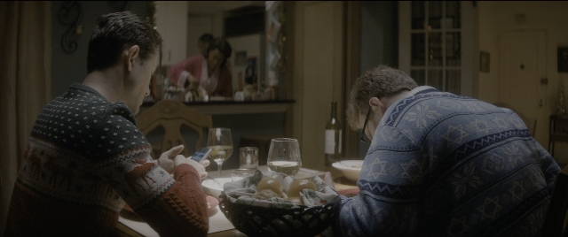 Wide shot frame from The Night Before — sitting, plate, room
